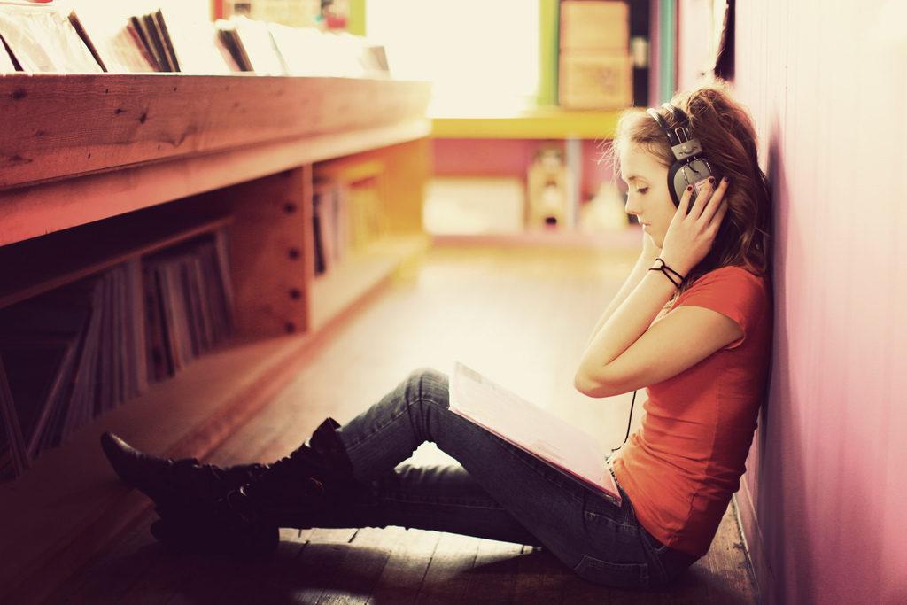 Девушка в наушниках слушает музыку